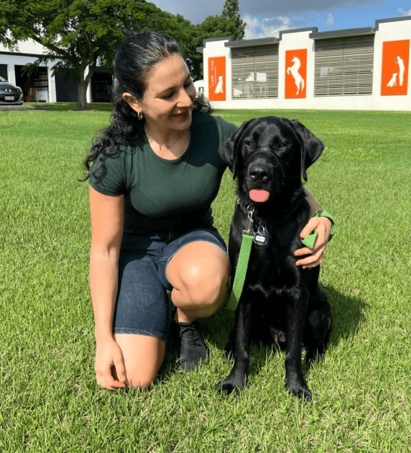 Nikki on the training field with Fergus, the black Labrador guide-dog puppy she raised