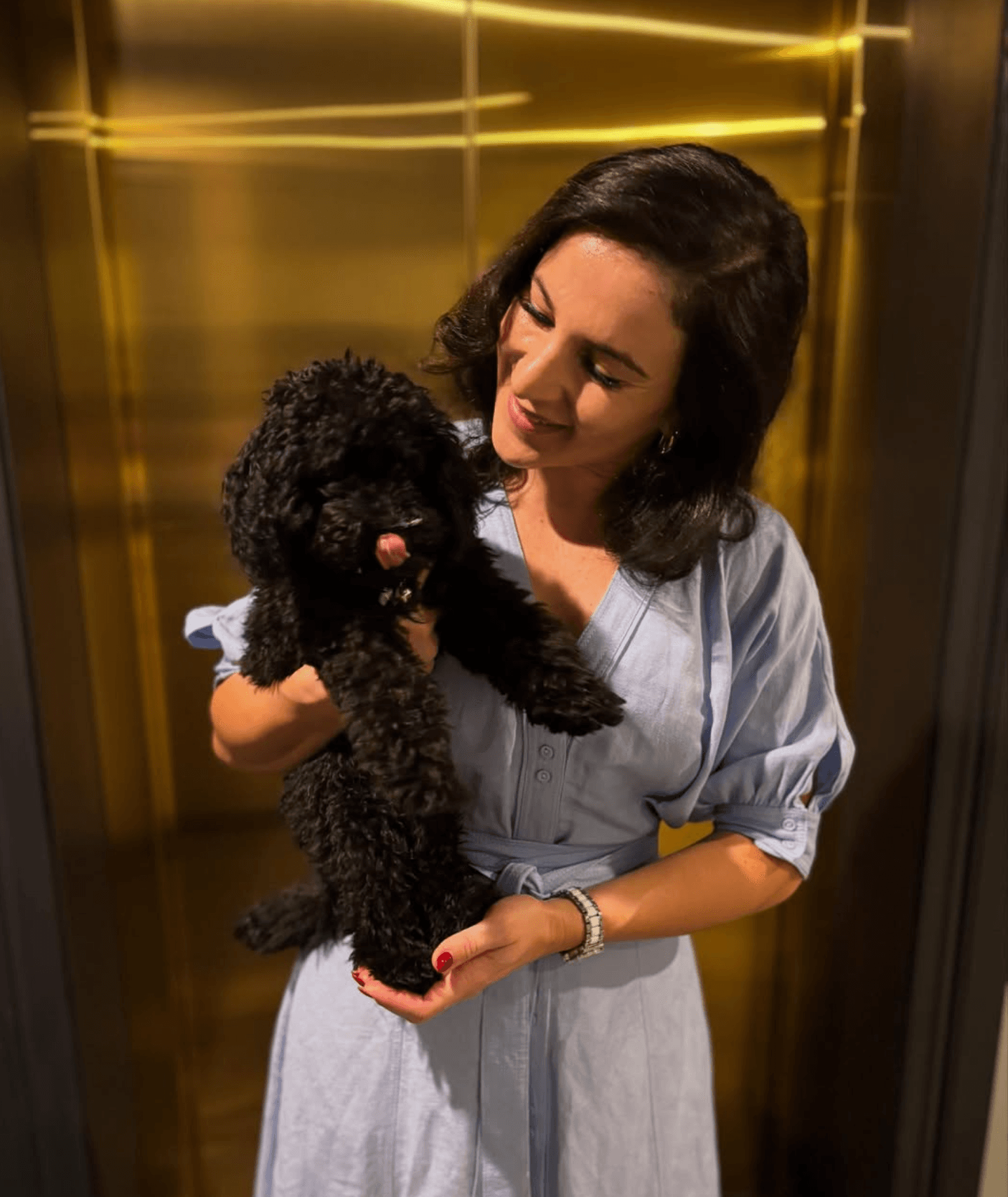 Nikki holding a small black dog, in-home dog sitter and walker in Brisbane